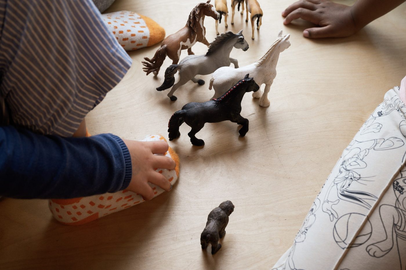 Kinder spielen mit Spielpferden im Kinderladen