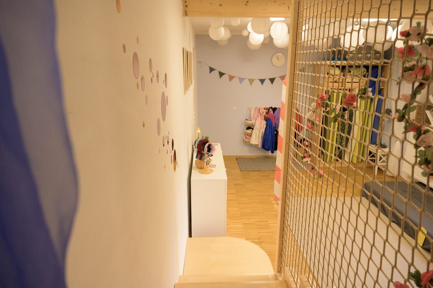 Verkleidungsecke mit Kletternetz und Wimpelkette im Kinderladen